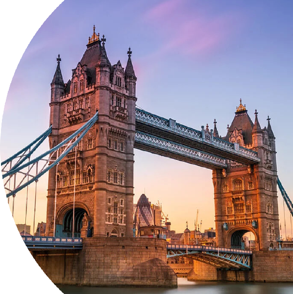 Iconic view of Tower Bridge in London at sunset, with the bridge's towers lit against the sky.